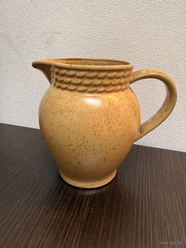 Керамический кувшин, выполненный в тёплых бежево-коричневых тонах с крапчатой текстурой.