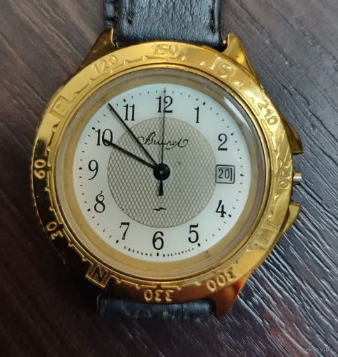 Винтажные наручные часы Вымпел имеет золотистый корпус и безель с гравировкой цифр , работоспособность не известна .